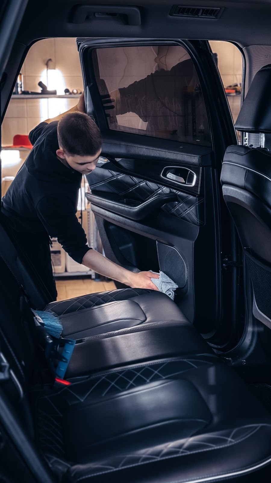 Technician cleaning a car's interior upholstery